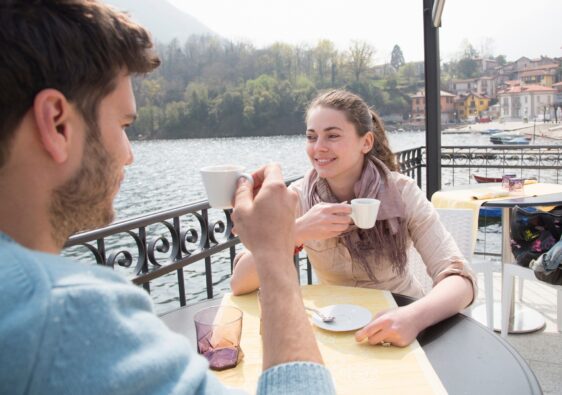 Couple drinking espresso at lakeside restaurant, Lake Mergozzo, Verbania, Piemonte, Italy