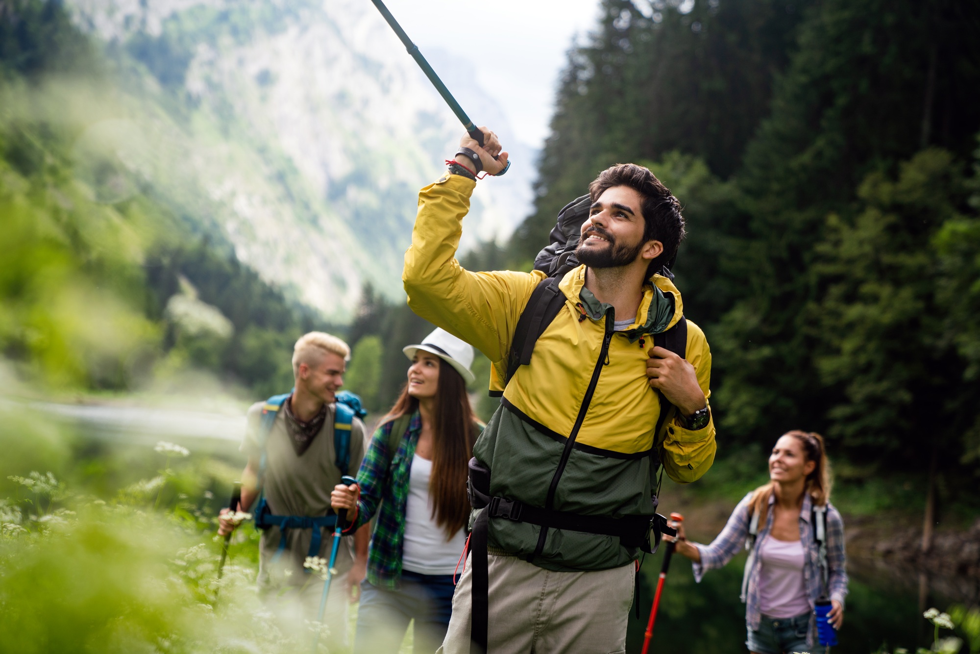 Group of happy fit friends hiking, trekking together outdoor nature