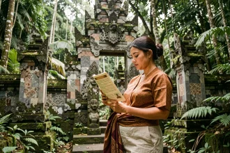 Touriste portant un sarong traditionnel à l'entrée du Sacred Monkey Forest d'Ubud, lisant les règles de visite affichées sur un panneau officiel